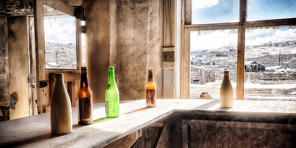 five bottles on bar counter in dechambeau hotel in bodie california