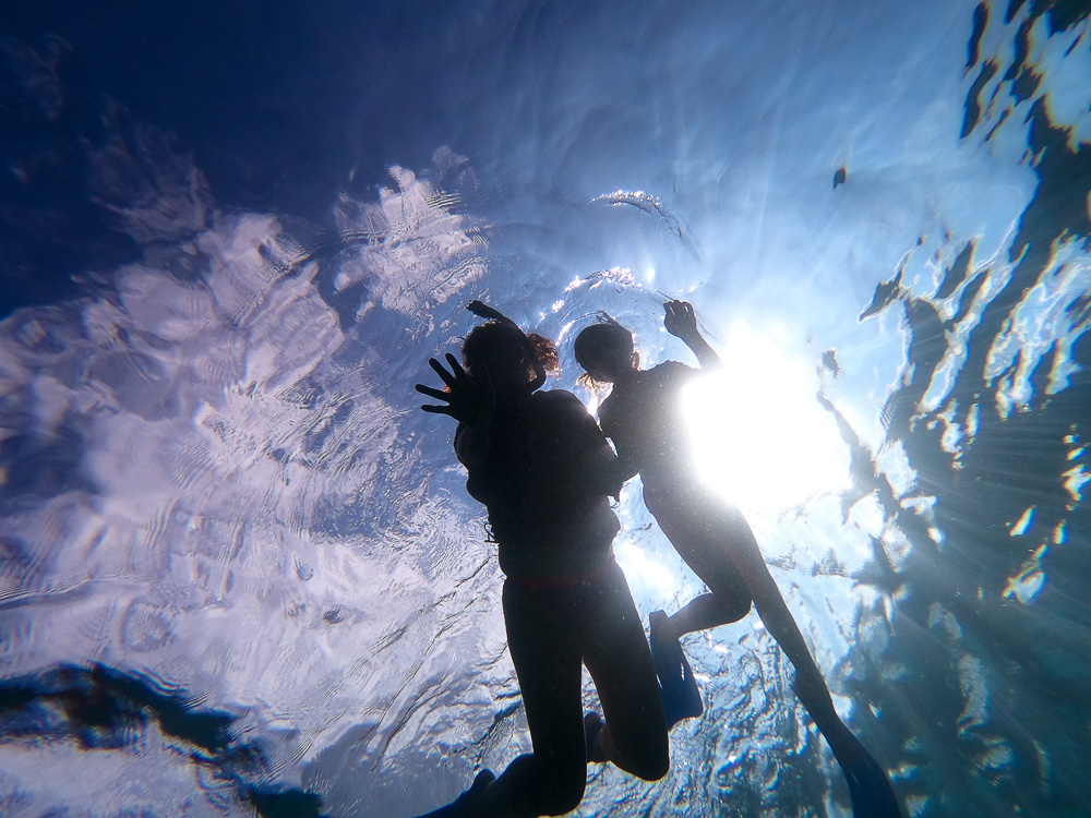 mother and daughter snorkeling in hawaii holding hands