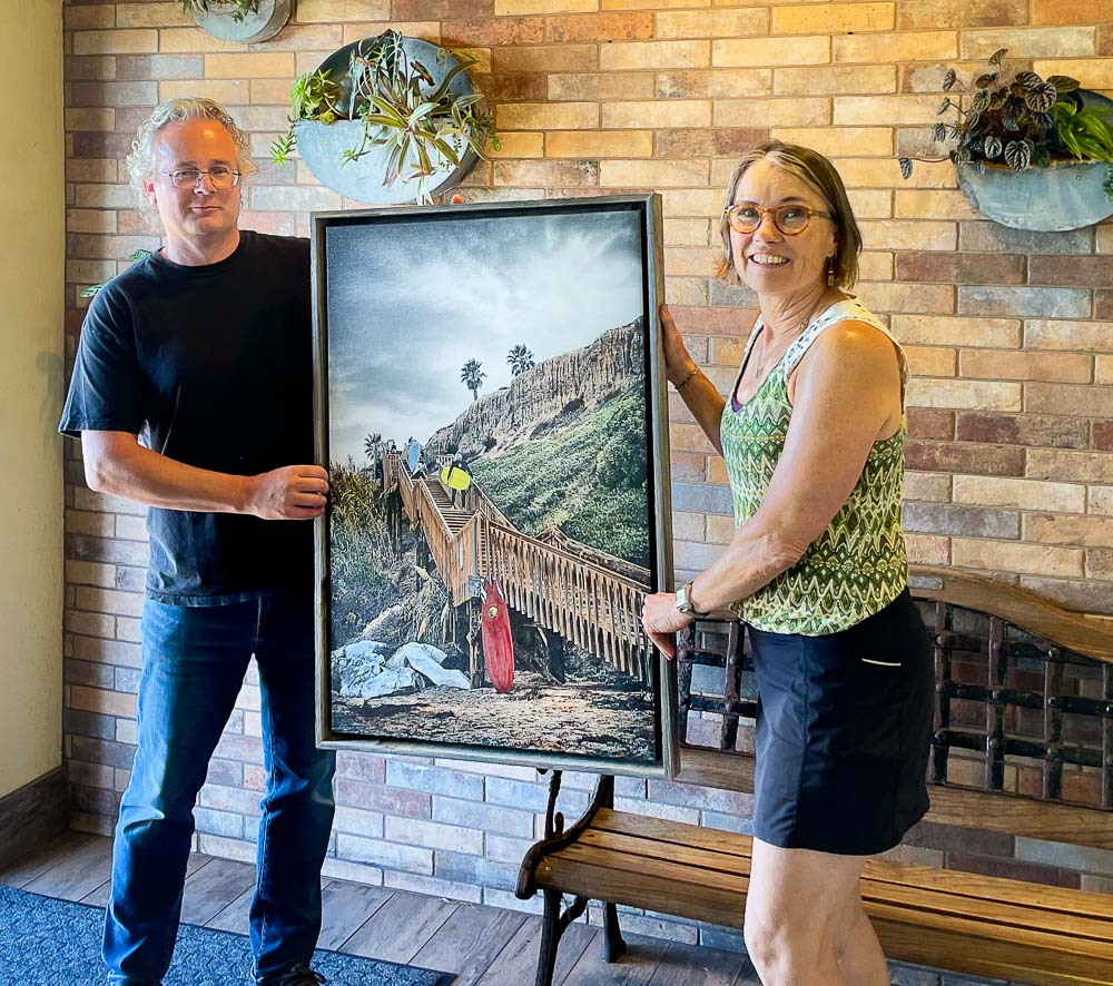 roy and lorraine holding red yellow and blue mixed media piece