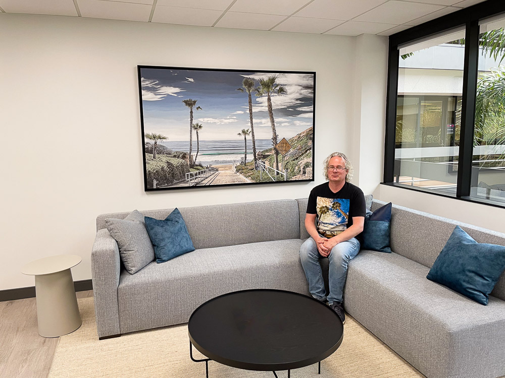 roy sitting in front of large fletcher cove hand colored photo