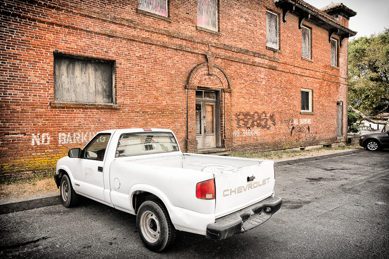 white pick up parked in front of no barking writing